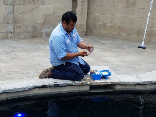 Pool is filled - Juan is testing the water during start-up to confirm that the water chemistry is balanced 